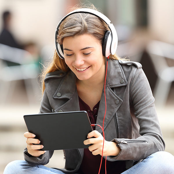 young woman watching video on tablet wearing headphones